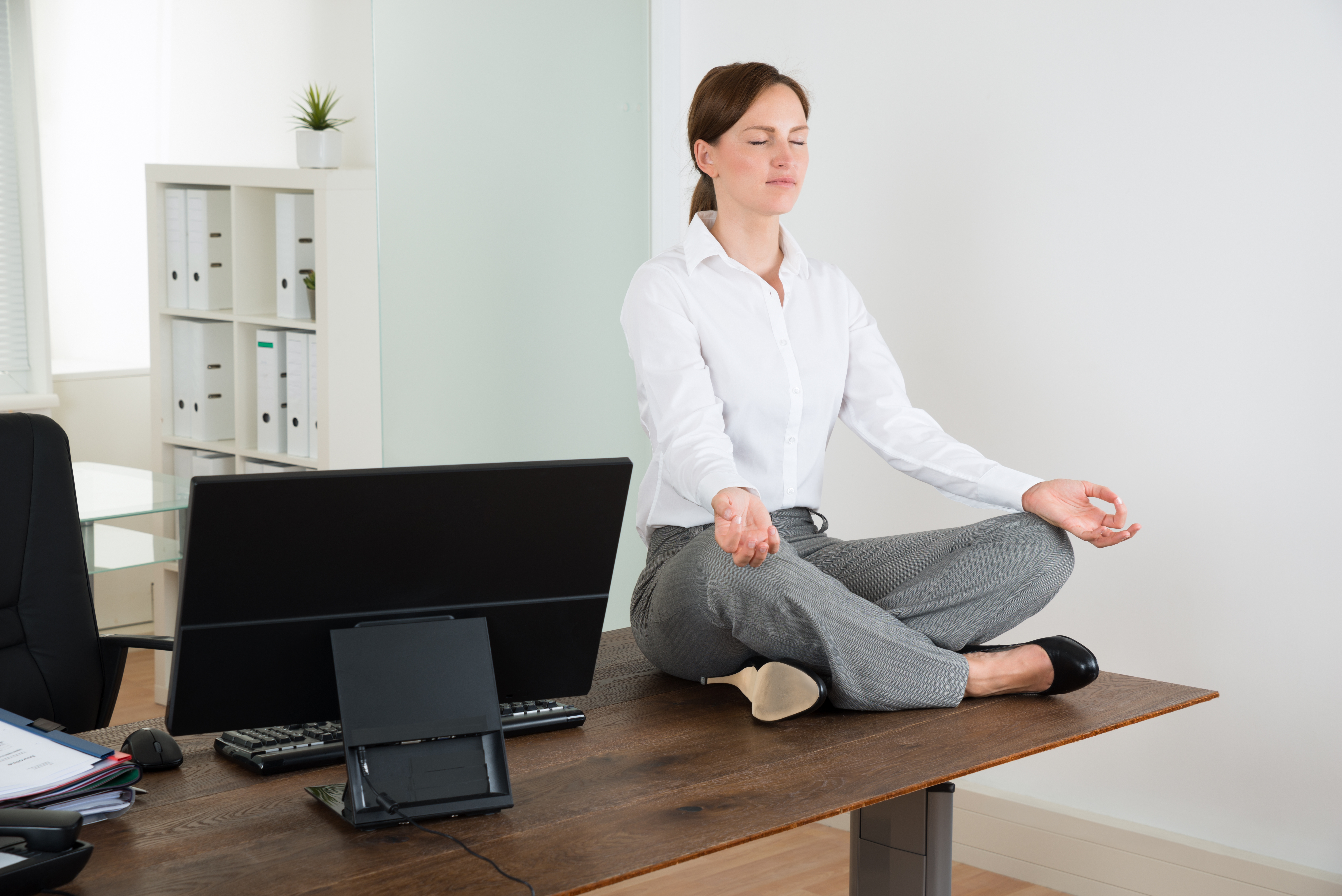Businesswoman Doing Yoga In Office